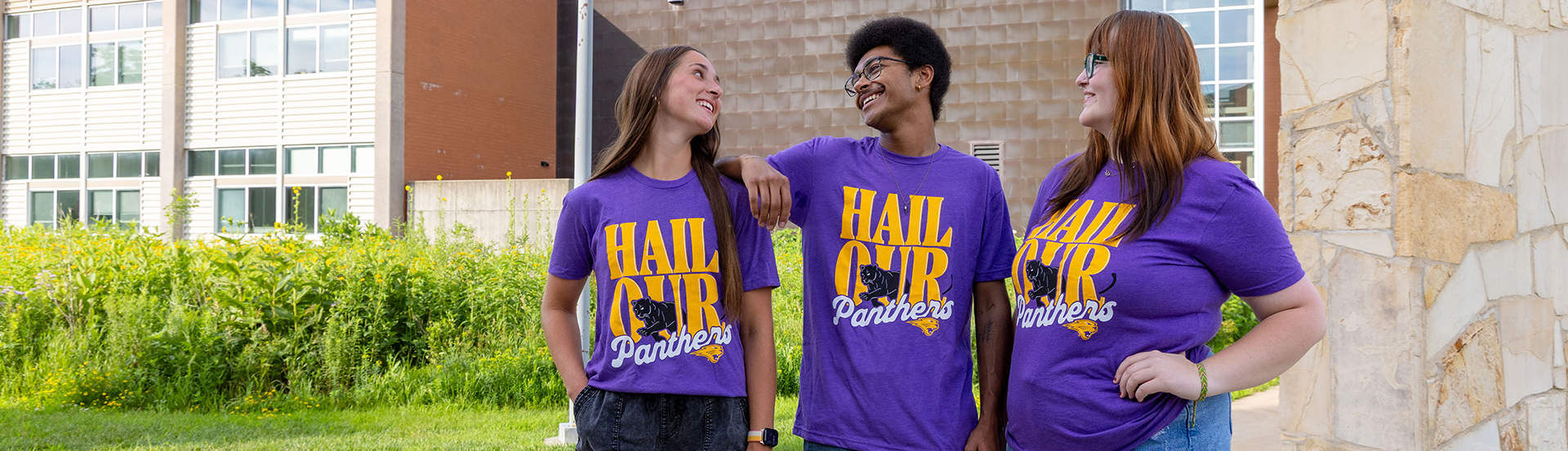 Three students looking at each other and laughing wearing Hail Our Panthers TC's Tees t-shirt